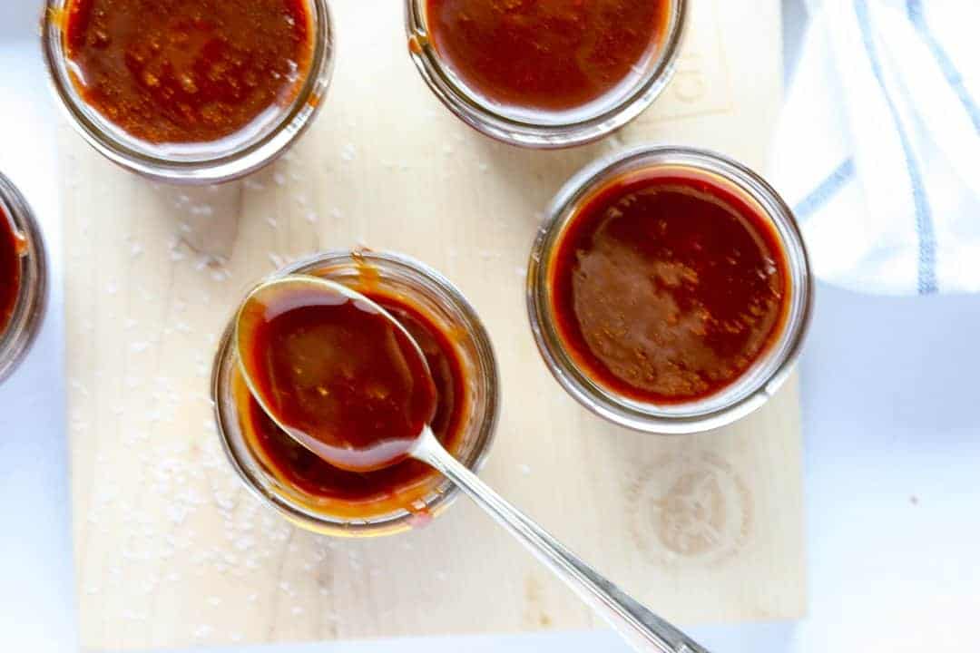 Four jars of caramel with a spoon