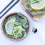 A close up of food on a table, with cucumber and lemon