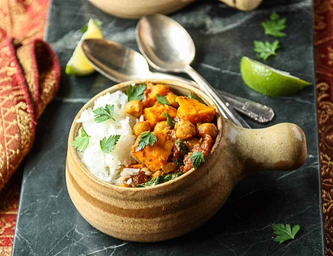 Sweet Potato Chickpea Curry with rice in a pottery bowl.