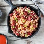 A pan of rice and red beans on top of a wooden table
