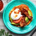 A breakfast taco on a plate sitting on top of a wooden table