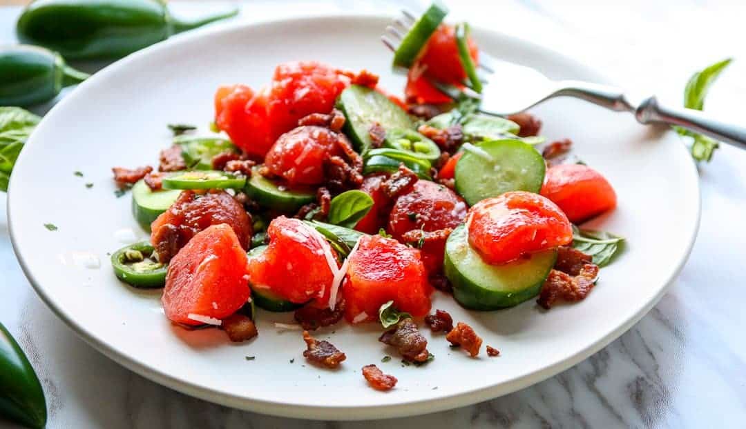 A plate of food on a table, with Salad and Watermelon