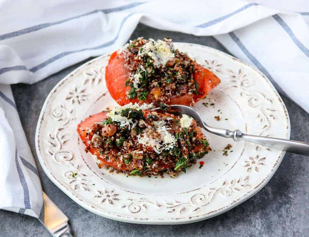 A plate of food on a table, with Quinoa and Stuffed tomatoes