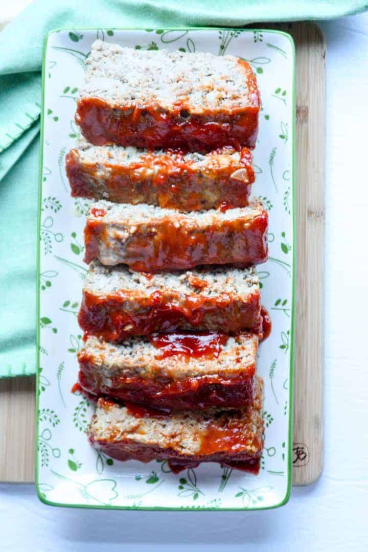 Six over-lapping slices of glazed turkey meatloaf on a rectangular plate