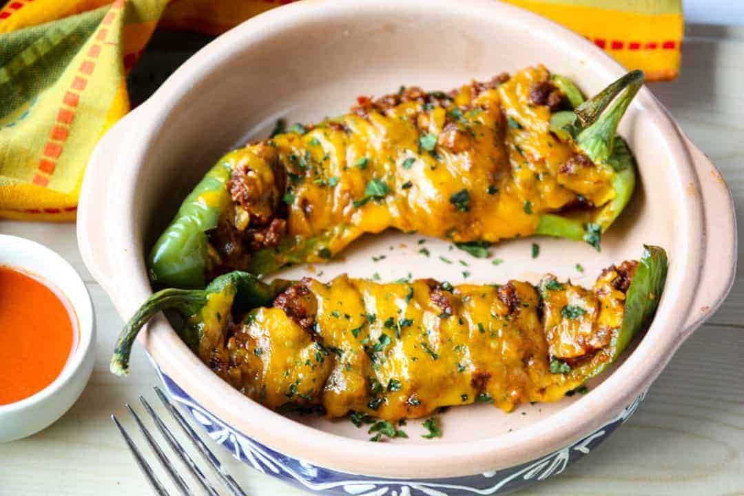 A bowl of food with peppers and cheese