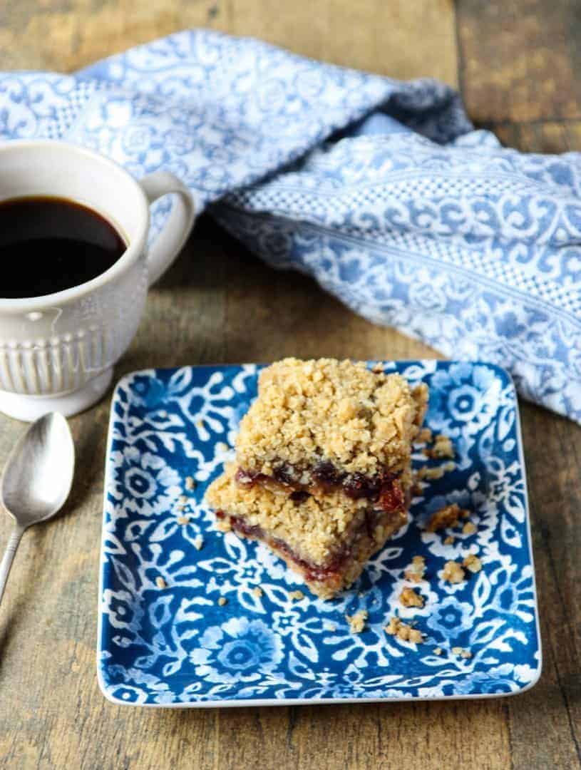 A cup of coffee on a table, with Cranberry and Date square