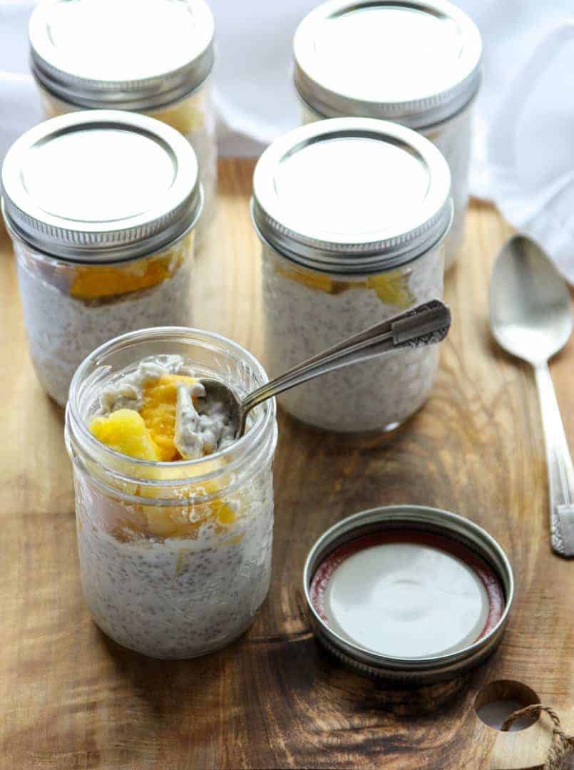 A glass jar of chia pudding with a spoon in it.