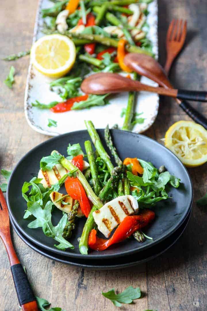 vegetable salad with fried cheese on a black plate