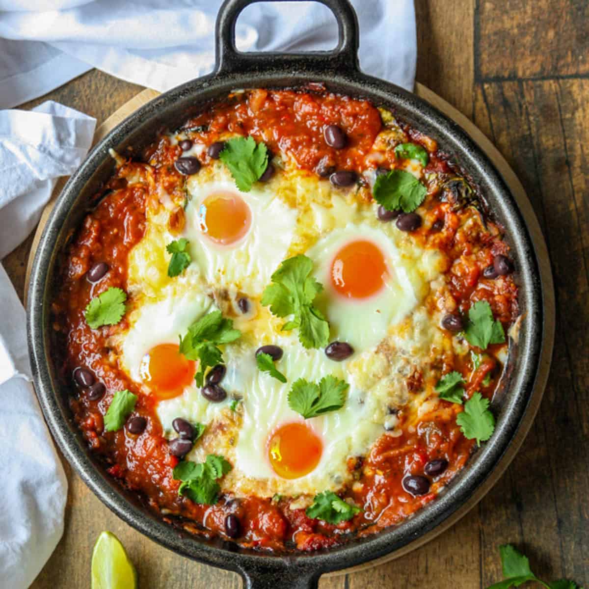 Huevos rancheros eggs in a cast iron skillet.