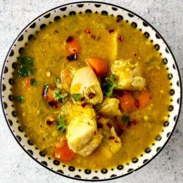 Turkey lentil soup in a black and white bowl.