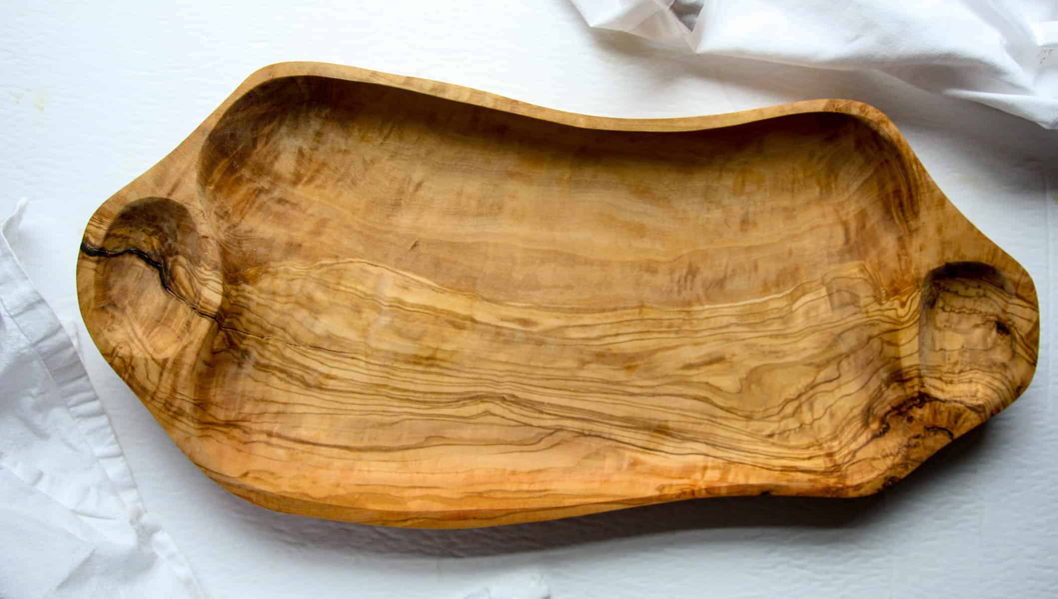 An empty irregularly shaped olive wood charcuterie board
