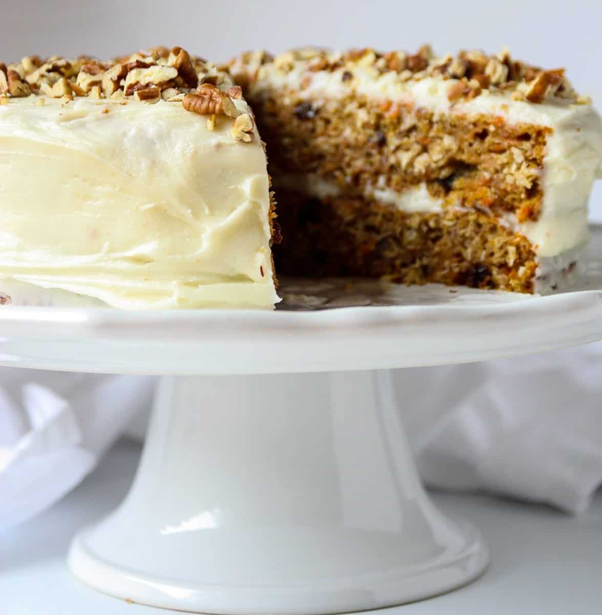 Gluten-Free Carrot Cake with cream cheese frosting on a cake stand.