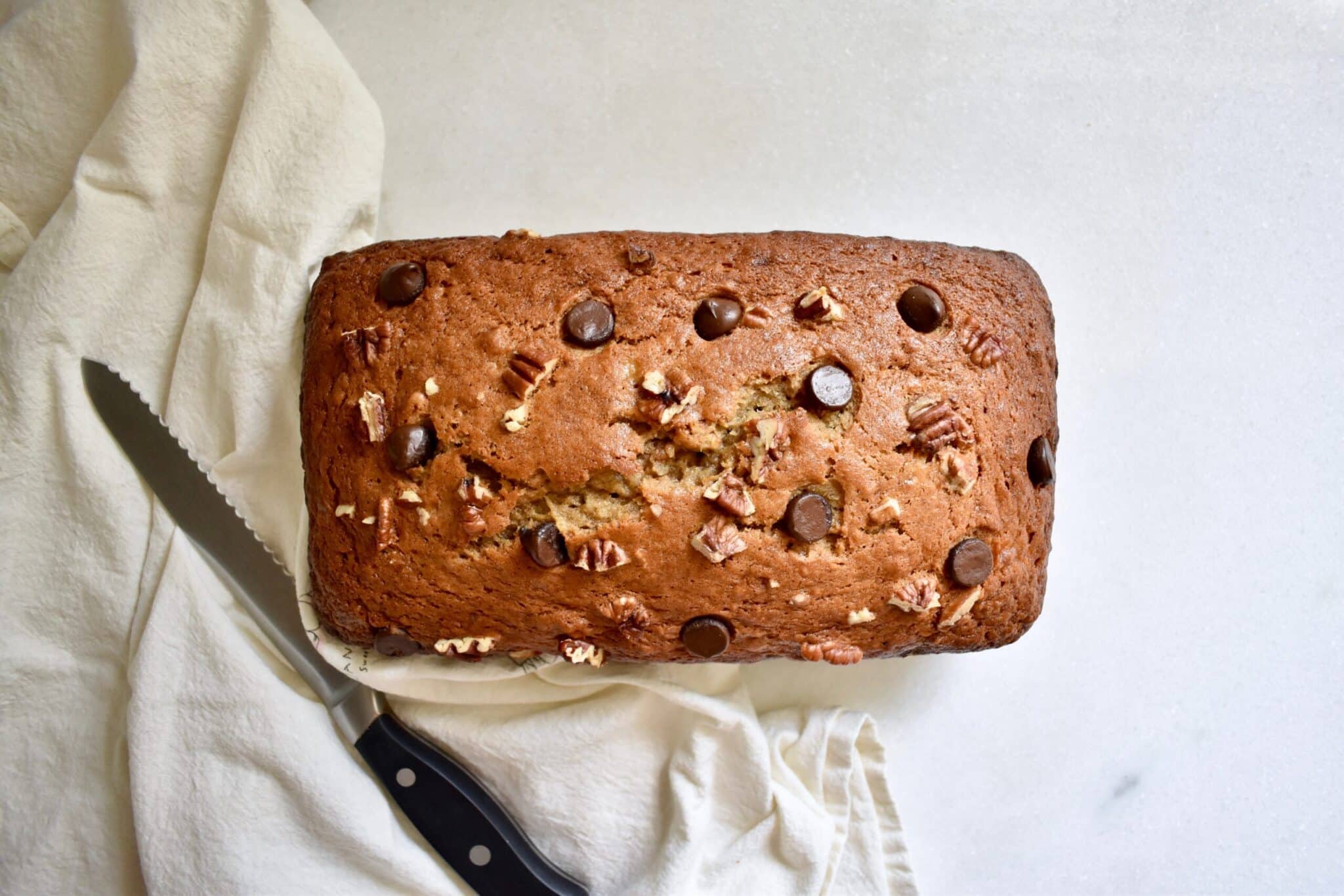 overhead shot of a banana bread loaf with chocolate chips and pecans