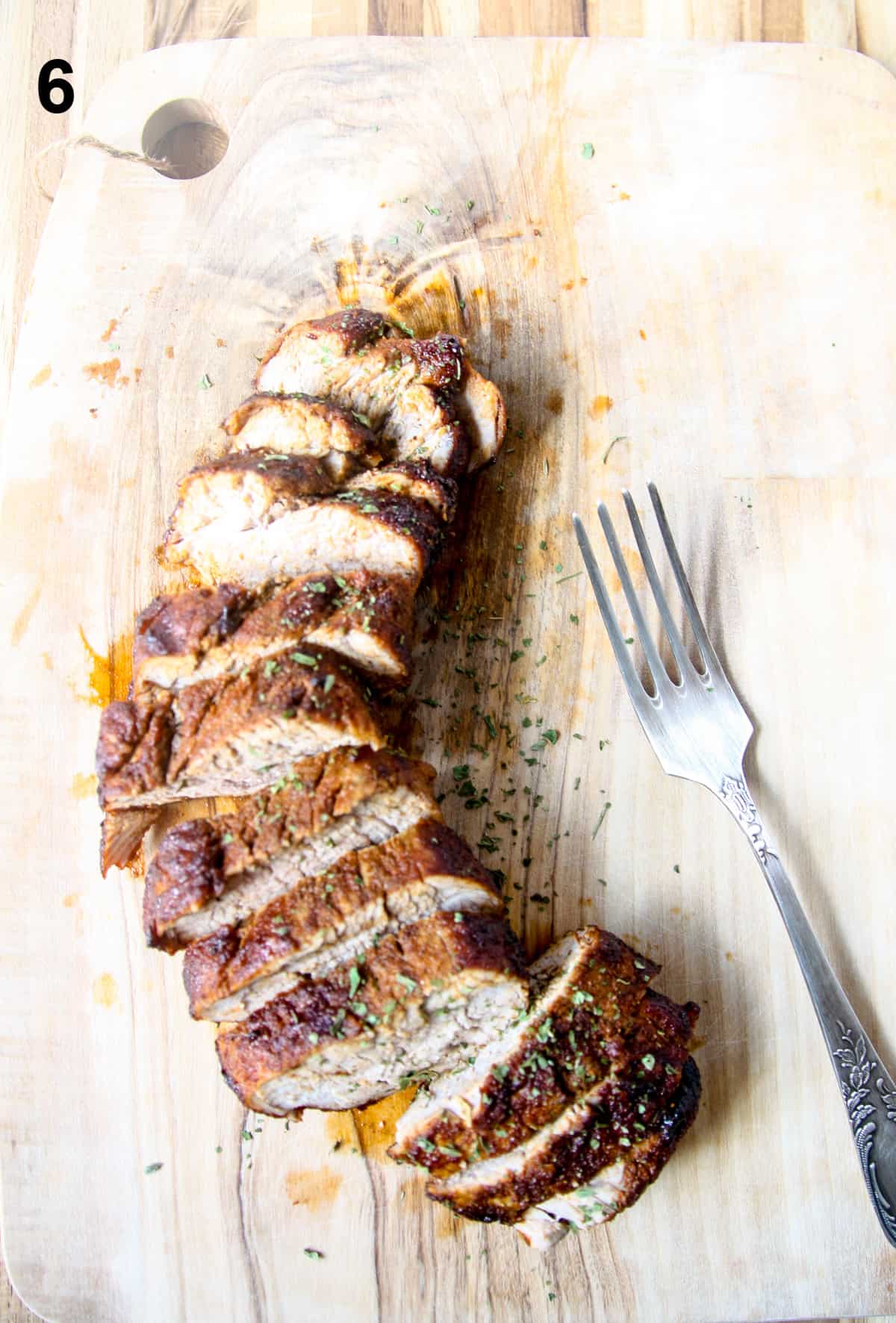 Sliced pork tenderloin on a cutting board.