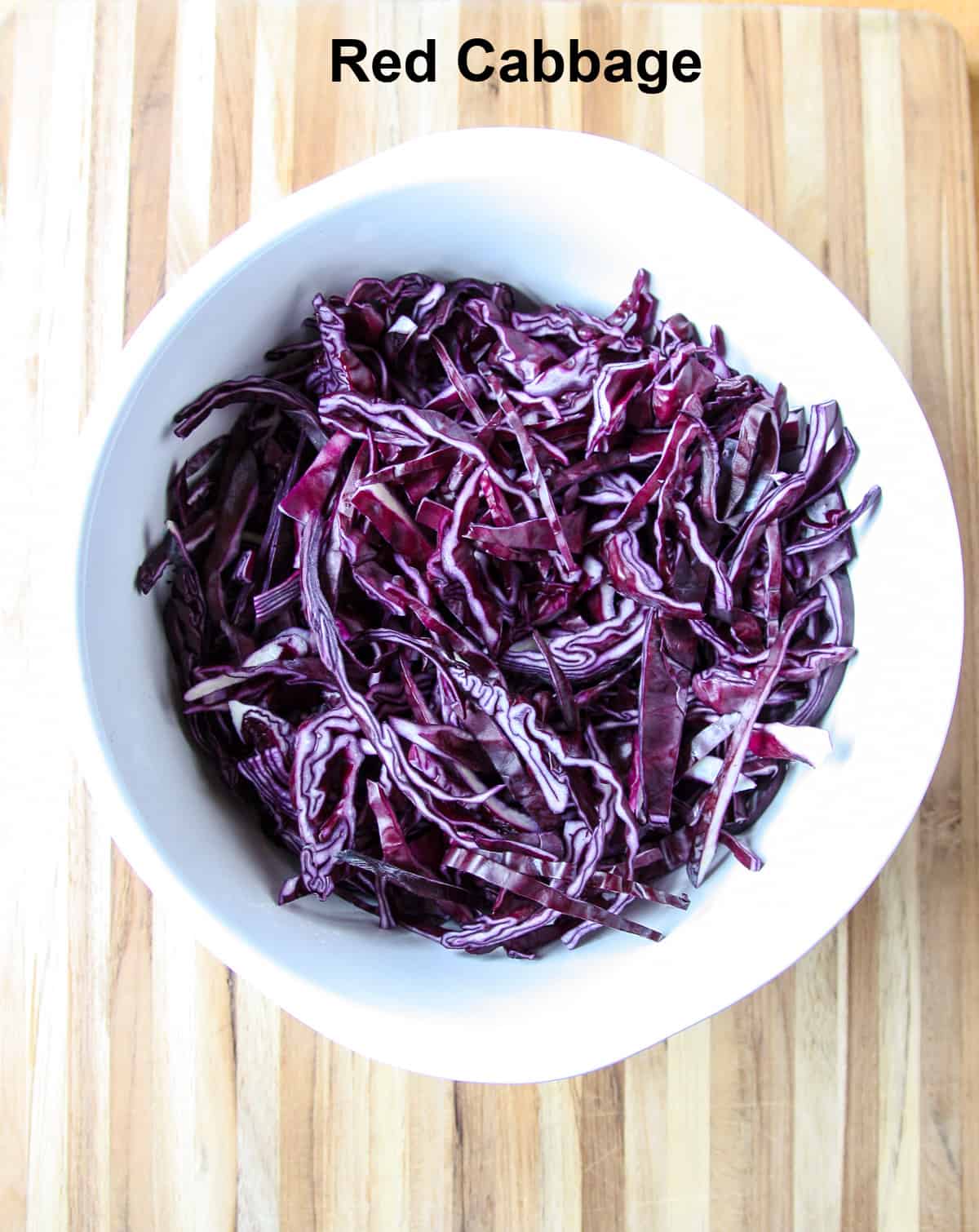 Shredded purple cabbage in a white ceramic bowl.