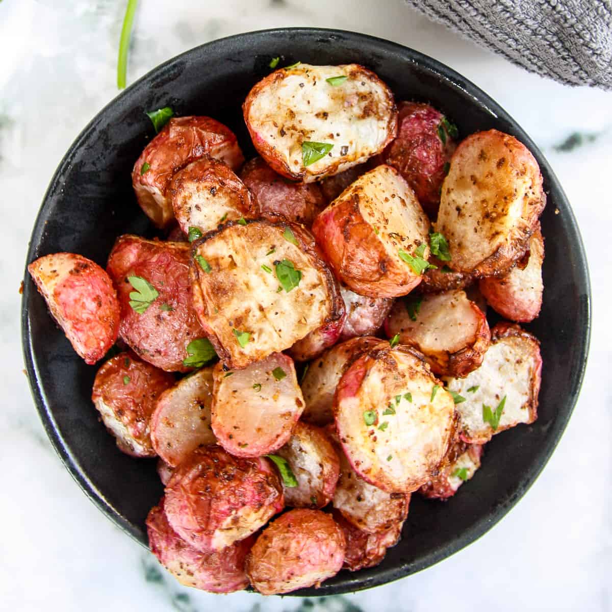 Air fried radishes in a black bowl.