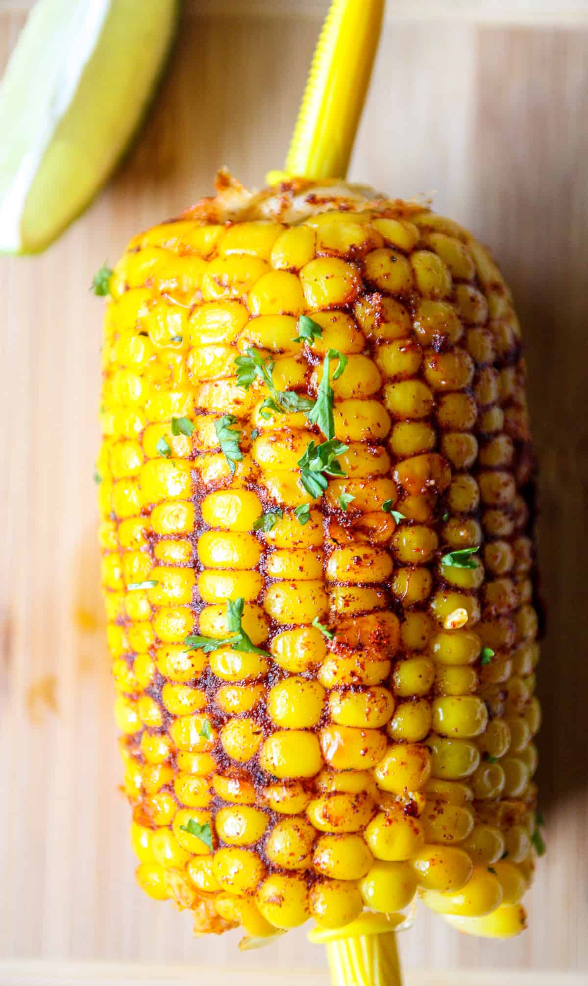 A Cajun corn on the cob garnished with parsley.