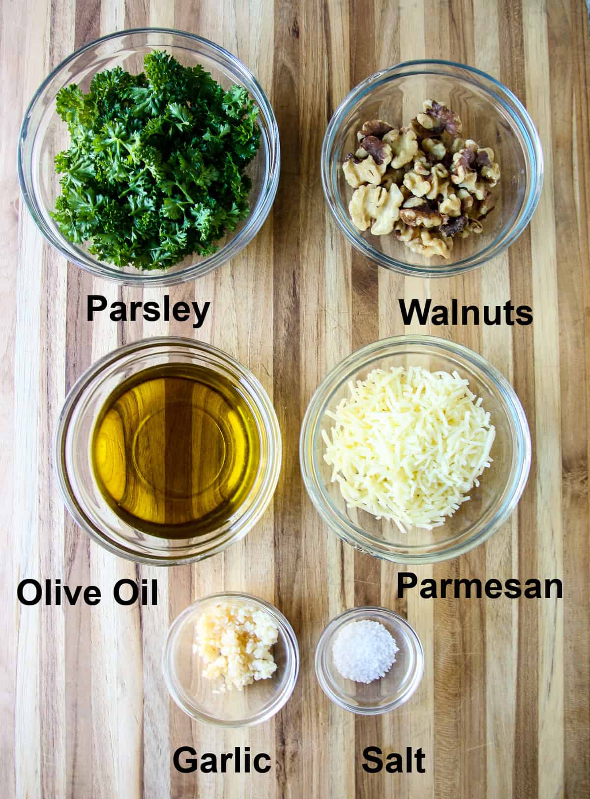 The ingredients required for this recipe in glass bowls on a wooden board.