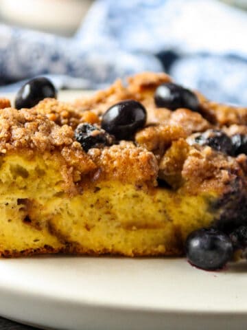 A slice of blueberry brioche French toast casserole on a white plate.