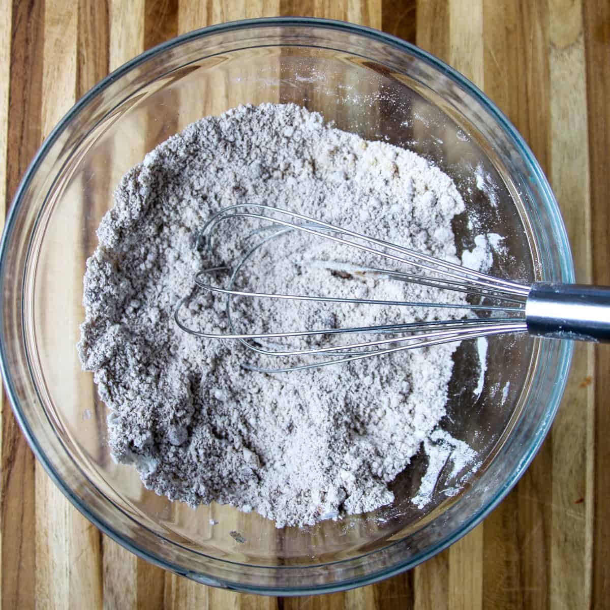 Streusel topping ingredients being whisked together in a glass mixing bowl.
