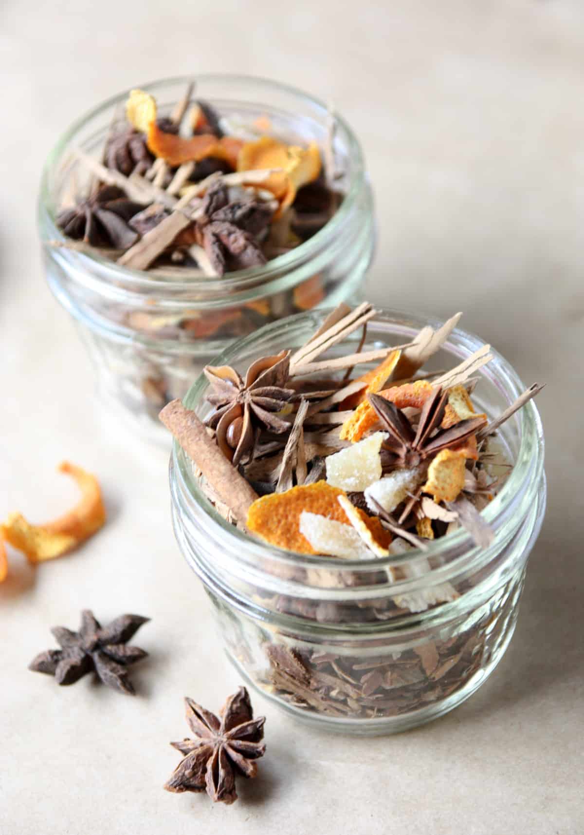 Two small glass jars filled with mulling spices.