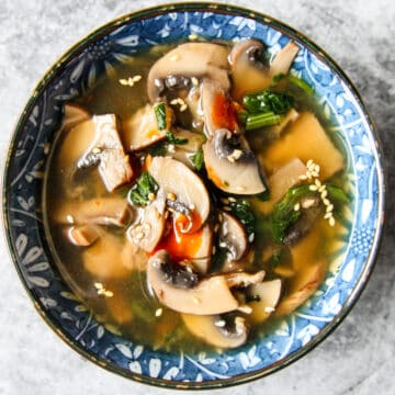 A blue and white bowl filled with miso mushroom soup.