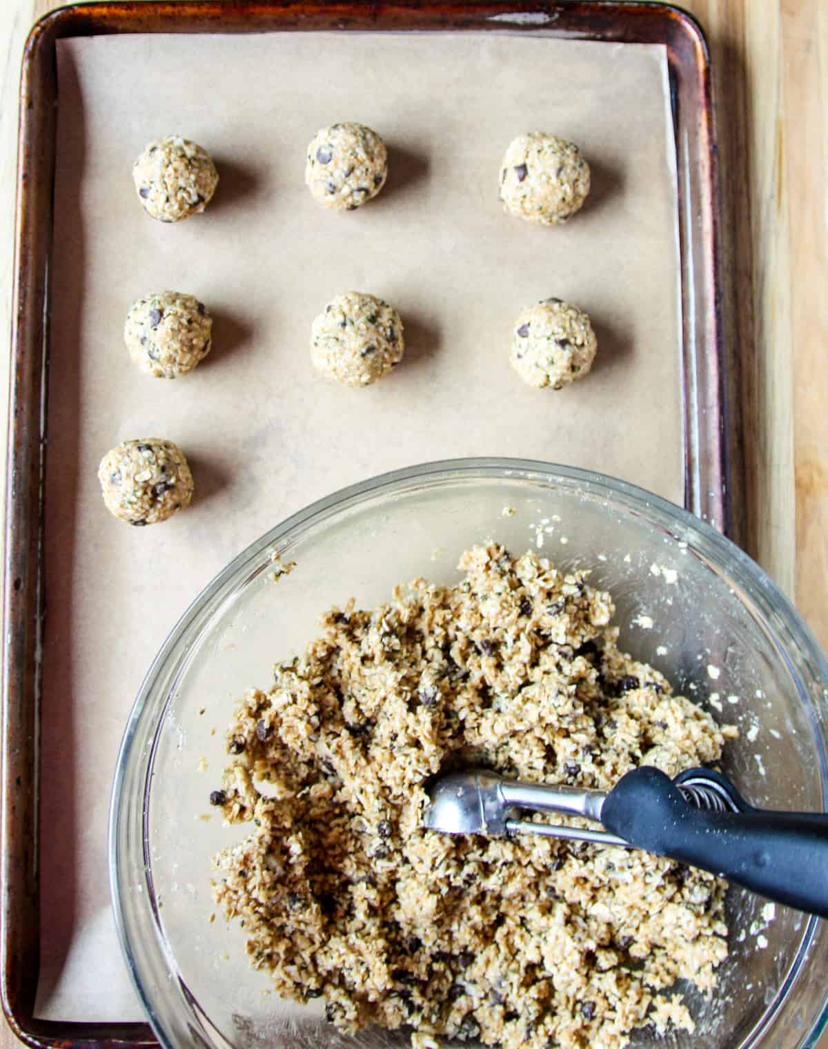 The mixture being scooped using a cookie scoop and rolled into balls.