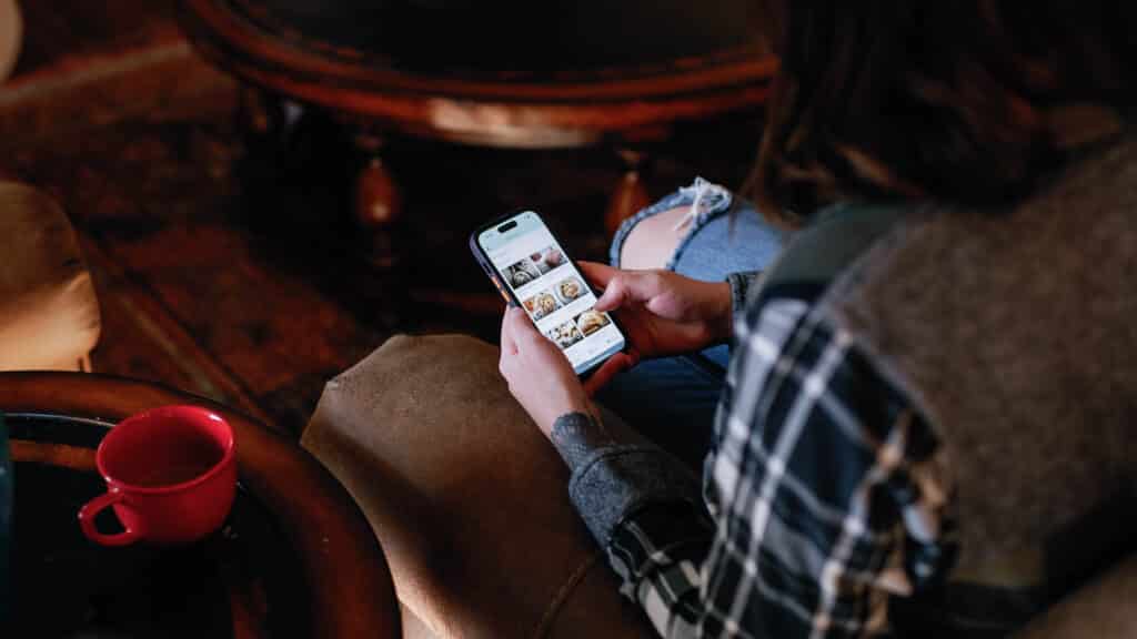 over the shoulder view of woman on her phone creating a meal plan