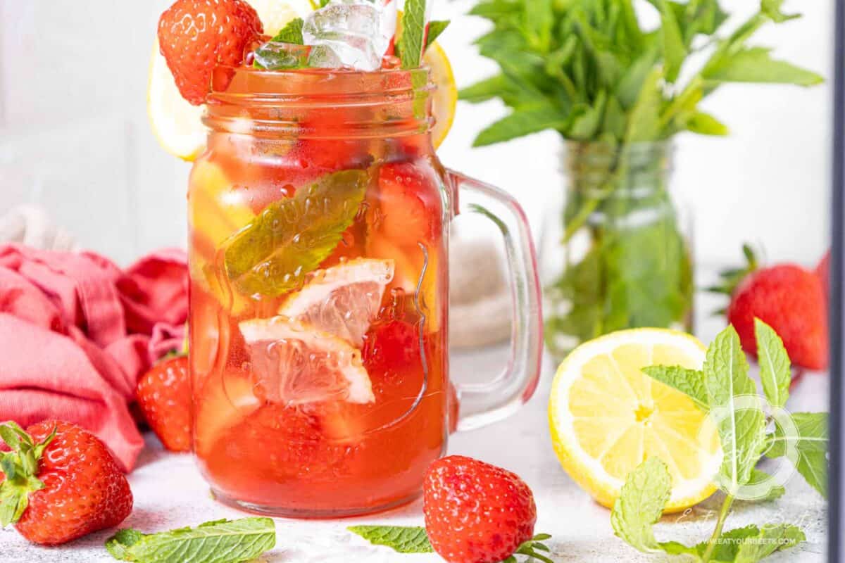 Strawberry mojito drink in a mason jar glass.