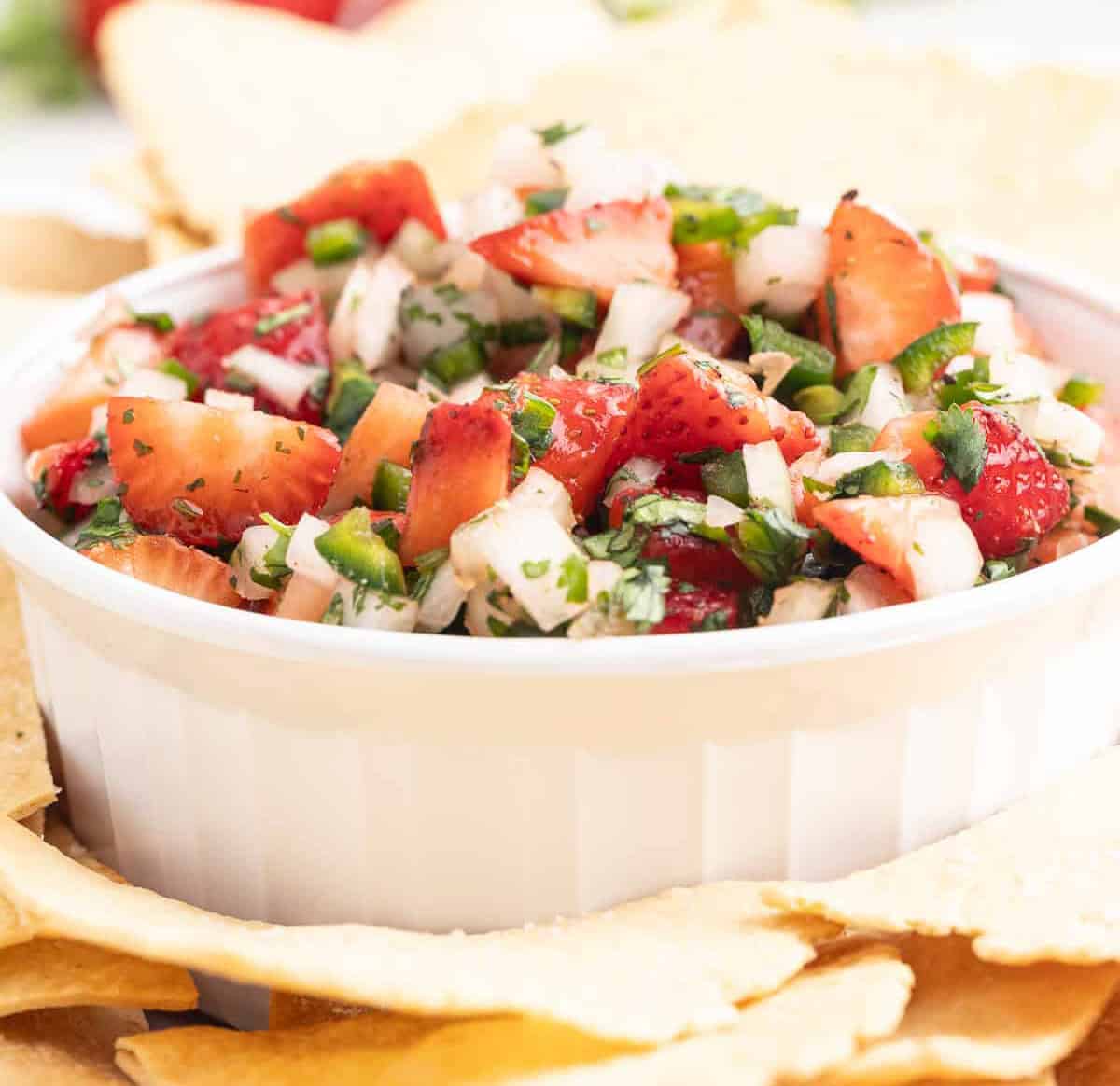 A white bowl filled with strawberry salsa.