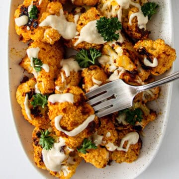 Roasted cauliflower drizzled with tahini sauce.