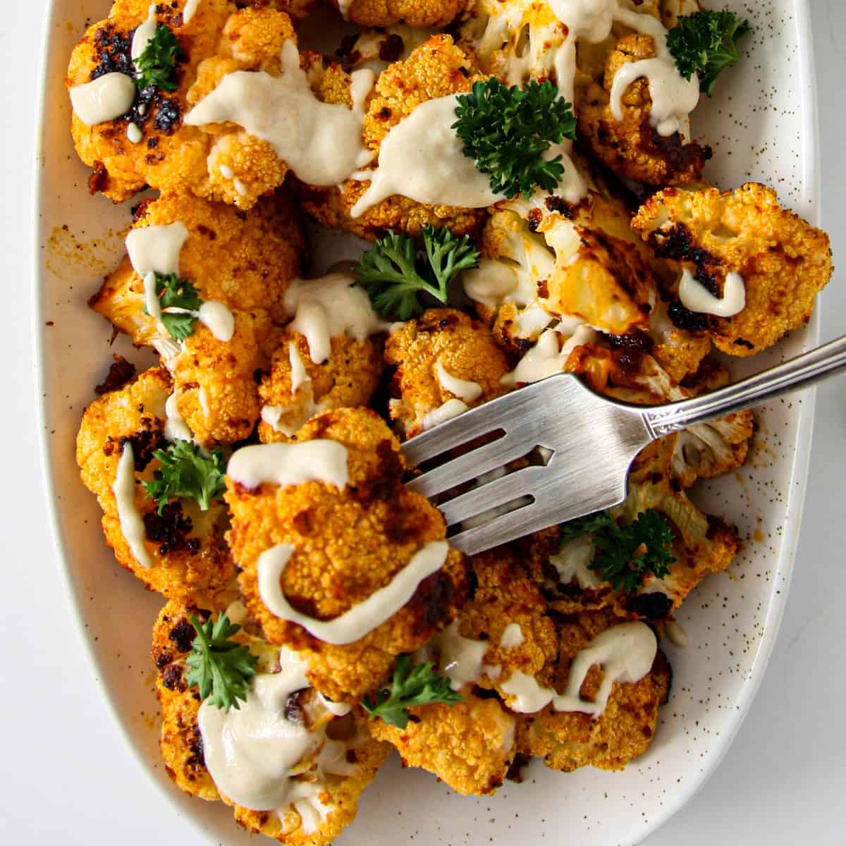 Roasted cauliflower drizzled with tahini sauce.