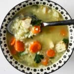 Turkey and rice soup in a black and white bowl.