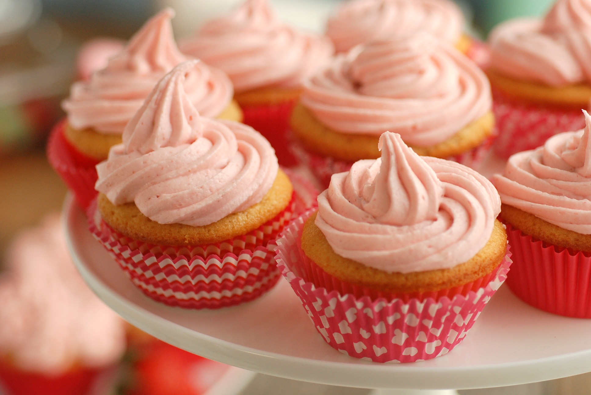 pink frosted cupcakes on a white plate